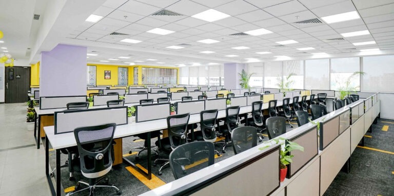 Corporate boardroom with long polished table, ergonomic leather chairs, and panoramic city view through large windows